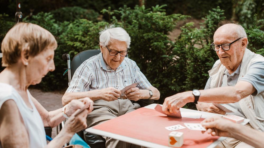 2 oude mannen en 1 oude vrouw die samen kaarten spelen